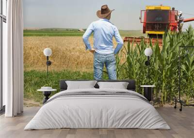 Farmer in field during harvest Wall mural