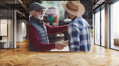 Farmers shaking hands in front of tractor on cattle farm Wall mural