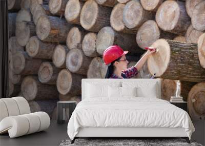 Female forest engineer beside logs Wall mural