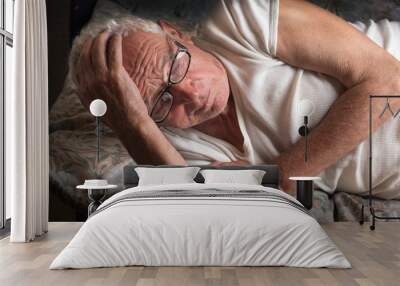 Old man lying in bed Wall mural