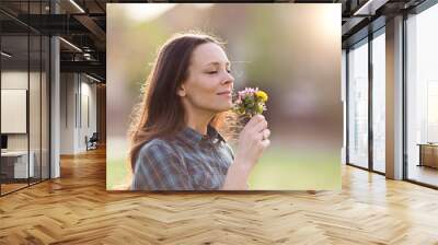 Pretty woman smelling flowers Wall mural