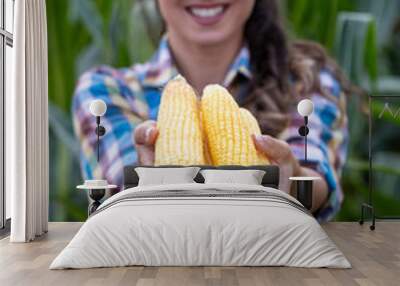 Woman holding corn cobs in hands Wall mural