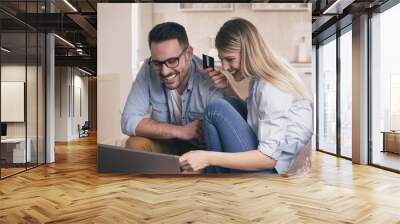 Young couple shopping online at home Wall mural