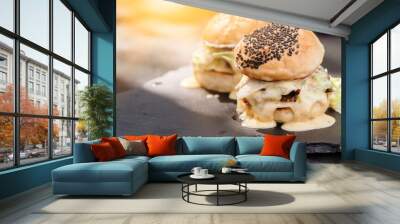 Two fresh tasty homemade hamburgers with fresh vegetables, lettuce, tomato, cheese beside sliced tomatoes on a cutting board. Free space for text Wall mural