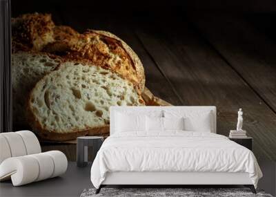 Bread, traditional sourdough bread cut into slices on a rustic wooden background. Concept of traditional leavened bread baking methods. Healthy food. Wall mural