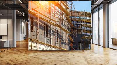 Extensive scaffolding providing platforms for work in progress on a new apartment block,Tall building under construction with scaffolds,Construction Site of New Building Wall mural