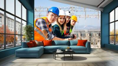 Group portrait of young workers in electric power station  Wall mural