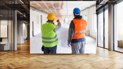 Photo shoot of two workers from behind on construction site Wall mural