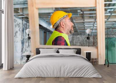 Plasterer man at work with trowel plastering the wall of interior construction site Wall mural