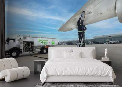 Technician is refueling aircraft with Sustainable Aviation Fuel (SAF) at the airport. Wall mural