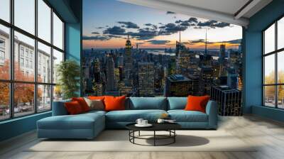 Aerial view of skyscrapers and towers in midtown skyline of Manhattan with evening sunset sky. Scenery cityscape of financial district with famous New York Landmark, illuminated Empire State Building Wall mural