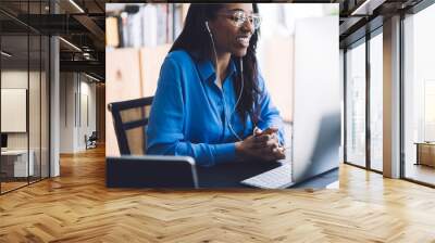 African American cheerful business female using computer with headphones Wall mural