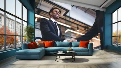 African American man smiling and shaking hands Wall mural