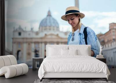 Attractive Caucasian tourist checking information from paper map for navigate own location during city sightseeing in ancient Rome,beautiful female traveller exploring Vatican city during Italian trip Wall mural