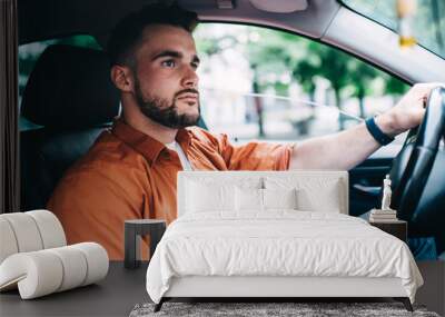 Bearded man in casual clothing driving car Wall mural