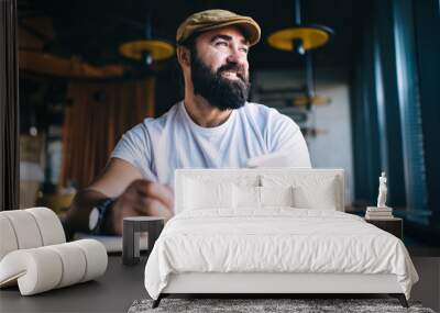 Bearded smiling man working in cafe Wall mural