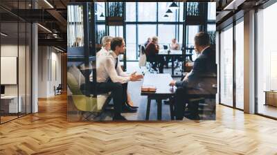 Businesspeople discussing strategy on couch in office lounge zone Wall mural