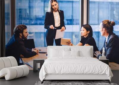 Businesswoman explaining company strategy to professional team of employees Wall mural