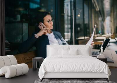 Busy female calling on mobile phone during remote work Wall mural