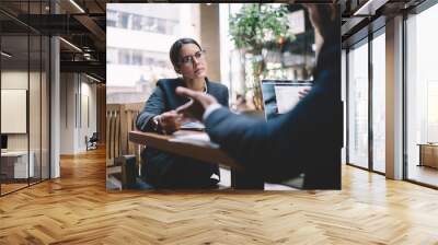 Careful businesswoman listening to colleague at workplace Wall mural