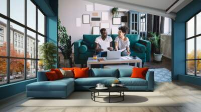 Cheerful black freelancers working on sofa Wall mural