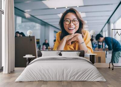 Cheerful female freelancer in workspace Wall mural