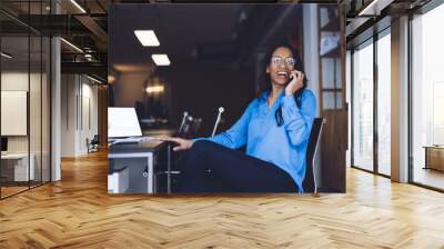 Cheerful female manager talking on mobile phone Wall mural