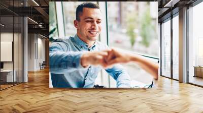 Cheerful male employee bumping fist making gesture of agreement satisfied with collaboration process,cropped image happy businessman knuckles with colleague making deal during planning startup Wall mural