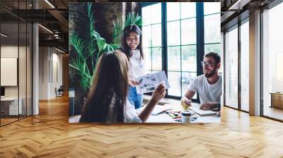 Cheerful multiethnic colleagues brainstorming together in workspace Wall mural