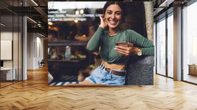 Cheerful woman messaging on smartphone Wall mural