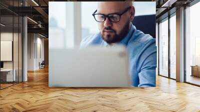 Concentrated bearded man using device Wall mural