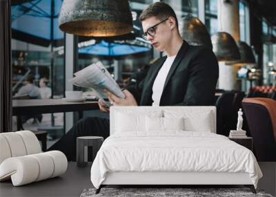 Concentrated businessman reading newspaper in cafeteria Wall mural