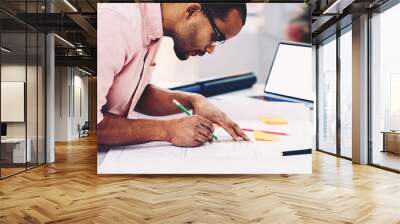 Concentrated on work engineer making sketch of construction while convert information into online drawing using laptop computer with mock up screen connected to wireless internet in coworking space Wall mural