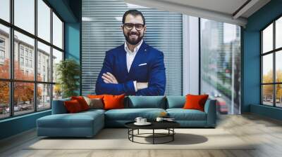 Confident cheerful male leader in stylish suit looking at camera and smiling during working time in office company, portrait of happy director in optical spectacles for provide eyes protection Wall mural