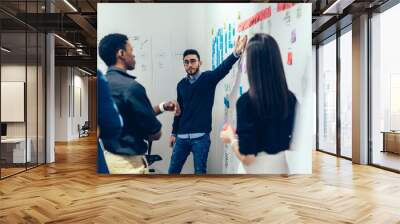 Contemporary multiethnic colleagues in formal wear arguing stickers on wall at office Wall mural