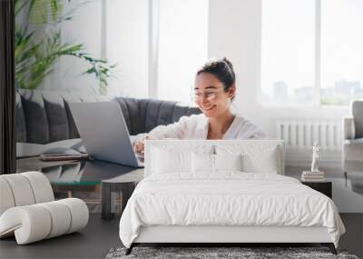 Content woman working on laptop in living room Wall mural