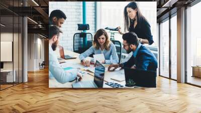 Crew of multicultural male and female partners coworking together on information for startup finance project, men and women analyzing management strategy for corporate company during collaboration Wall mural