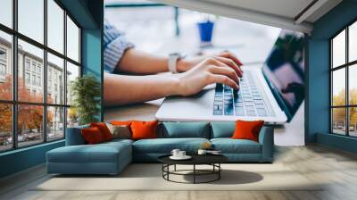 Cropped image of female hands typing on laptop computer connected to wifi working on freelance ,keyboarding on modern netbook for searching information online in networks for online business. Wall mural