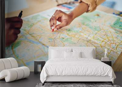 Cropped image of woman's hand pointing on mark on cartography planning adventure route on journey, top view of map of country checking direction and location for explore during travel vacation. Wall mural