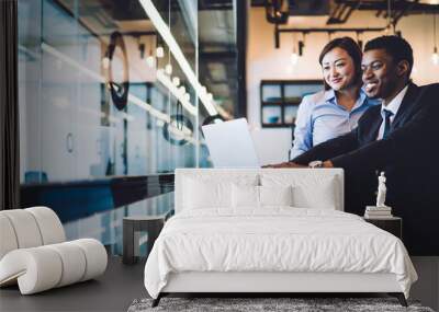 Diverse coworkers using laptop in modern office Wall mural