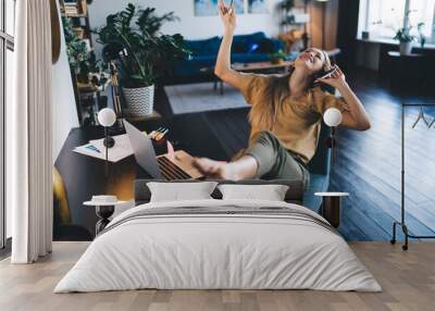 European girl talking on mobile phone at home Wall mural