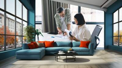 Focused colleagues working with papers in office Wall mural