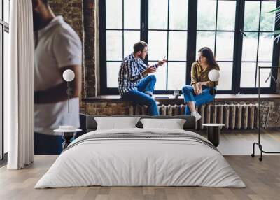 Focused coworkers resting on windowsill Wall mural