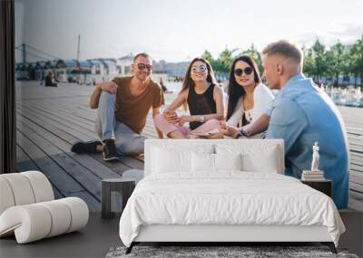 Friends spending together in park at weekend Wall mural