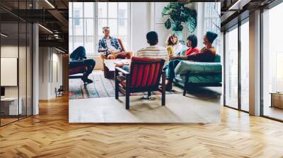 Group of delighted multiethnic friends chatting at home Wall mural