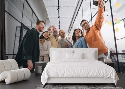 Group of diverse coworkers standing in office and taking self shot Wall mural