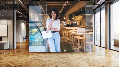 Half length of cheerful Caucaisan entrepreneur feeling success in franchise coffee shop standing in doorway and smiling at camera, happy self employed woman working in local cafeteria industry Wall mural