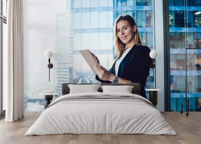 Half length portrait of cheerful female intelligent manager looking at camera using digital tablet for research in office, smiling business woman in elegant wear banking on touchpad enjoying gadget Wall mural