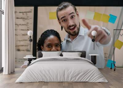 Half length portrait of cheerful multicultural male and female partners standing in office room and showing ok while smiling at camera, positive diverse coworkers enjoying entrepreneurship indoors Wall mural