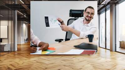 Happy male and female partners discussing new finance report with corporate productivity for future startup project, cheerful man communicating in office company and analyzing exchange occupation Wall mural